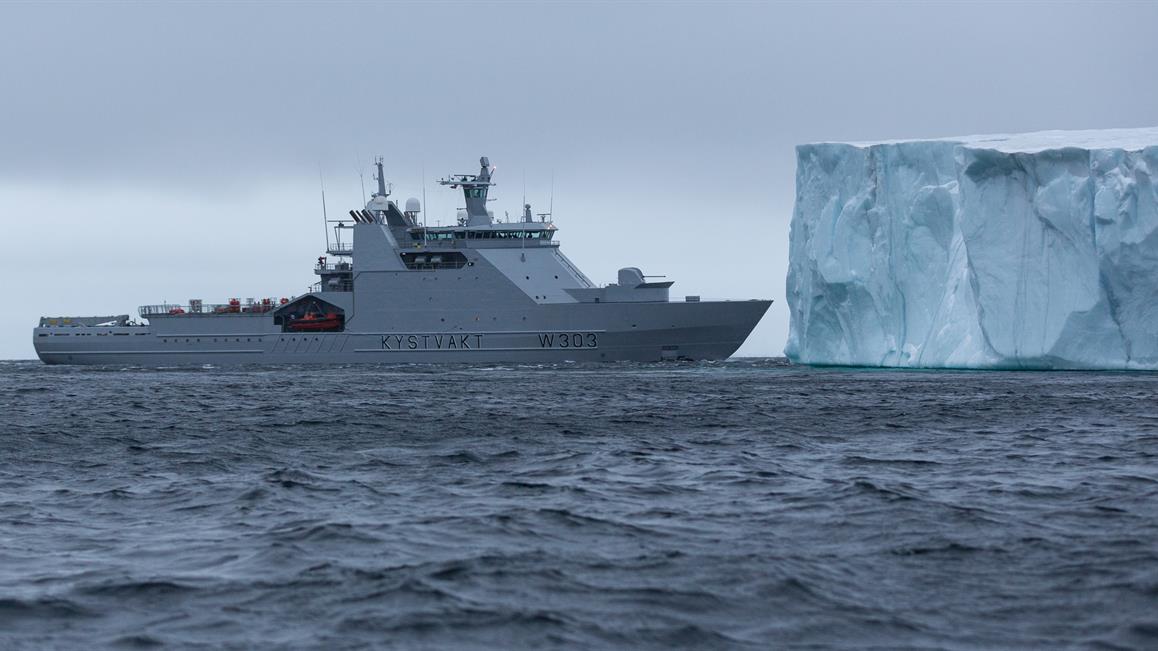Military vessel next to iceberg