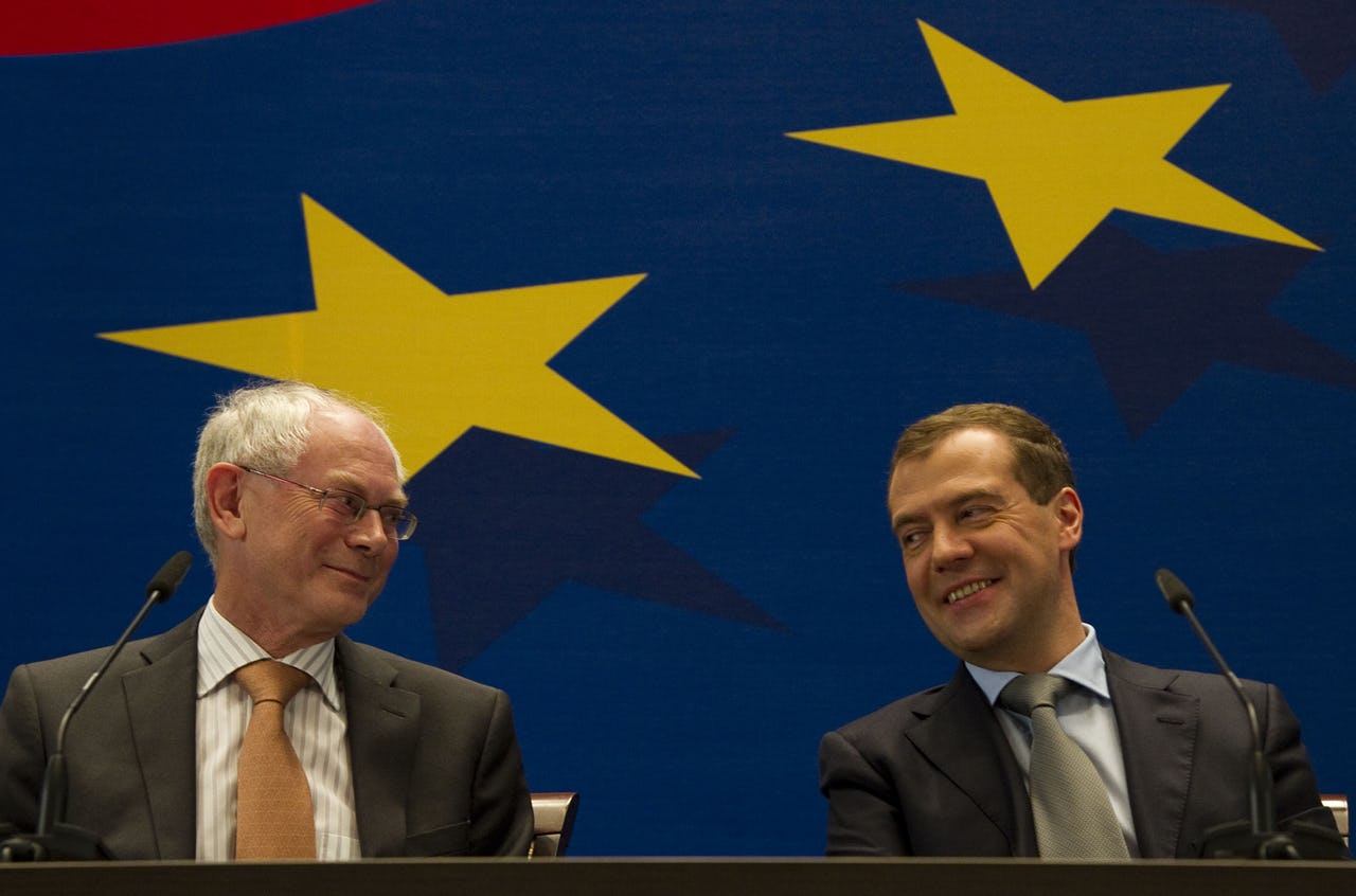 Two men sitting next to each other and laugh