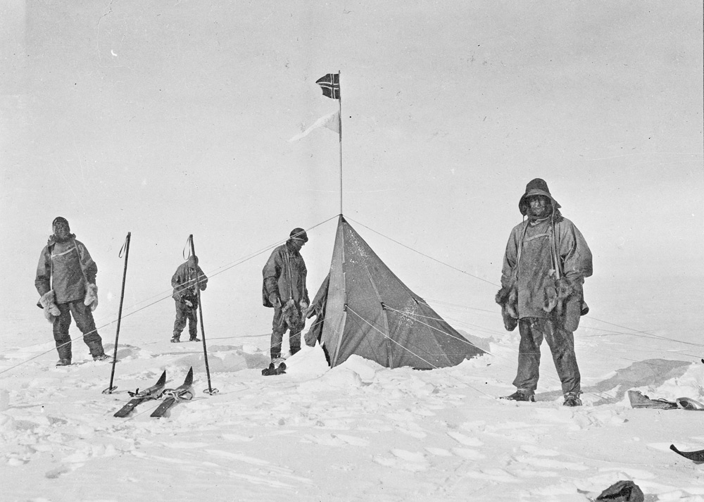 Black and white picture of men standing in front of tent at the South Pole