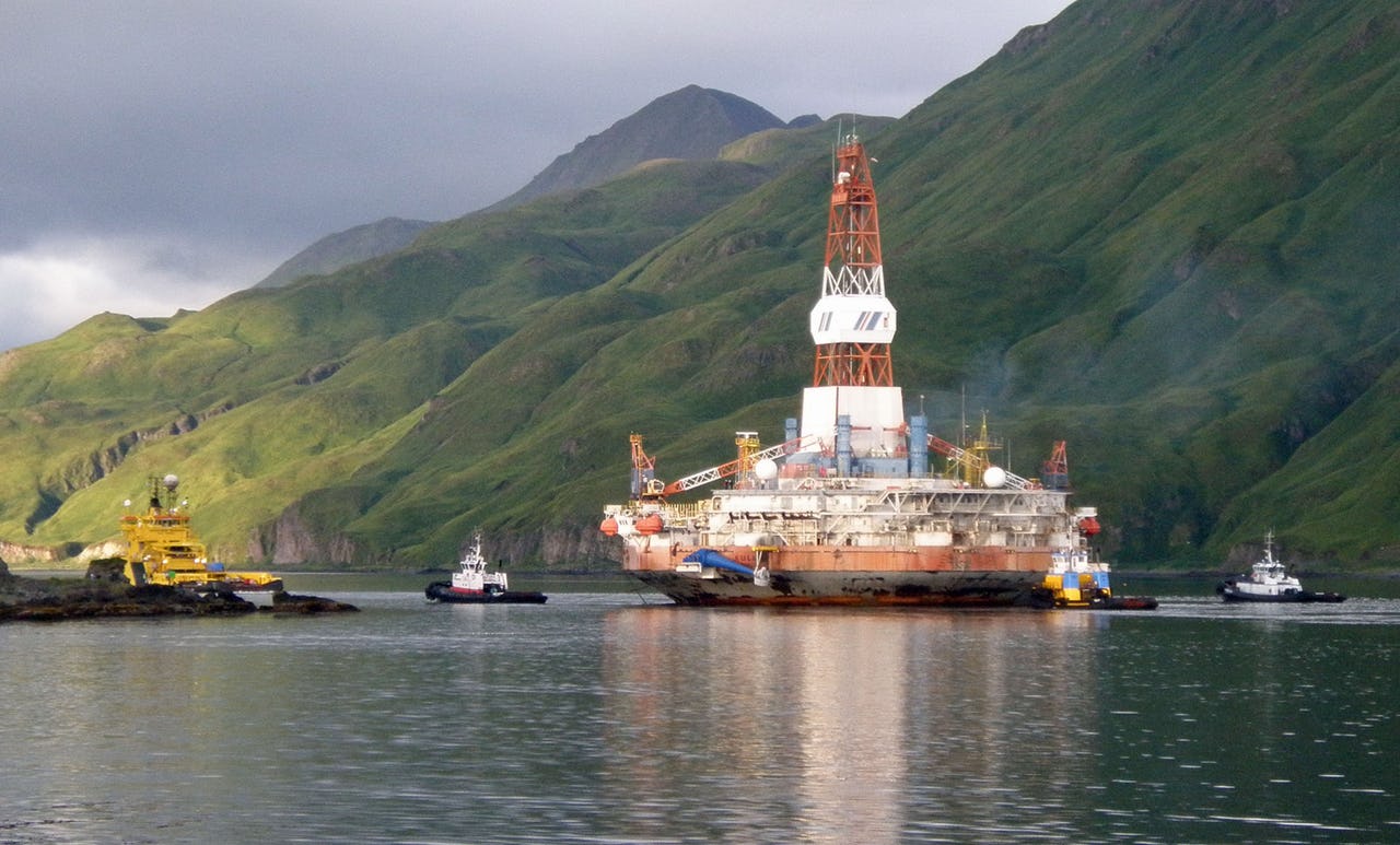 Oil drilling platform with mountains in background