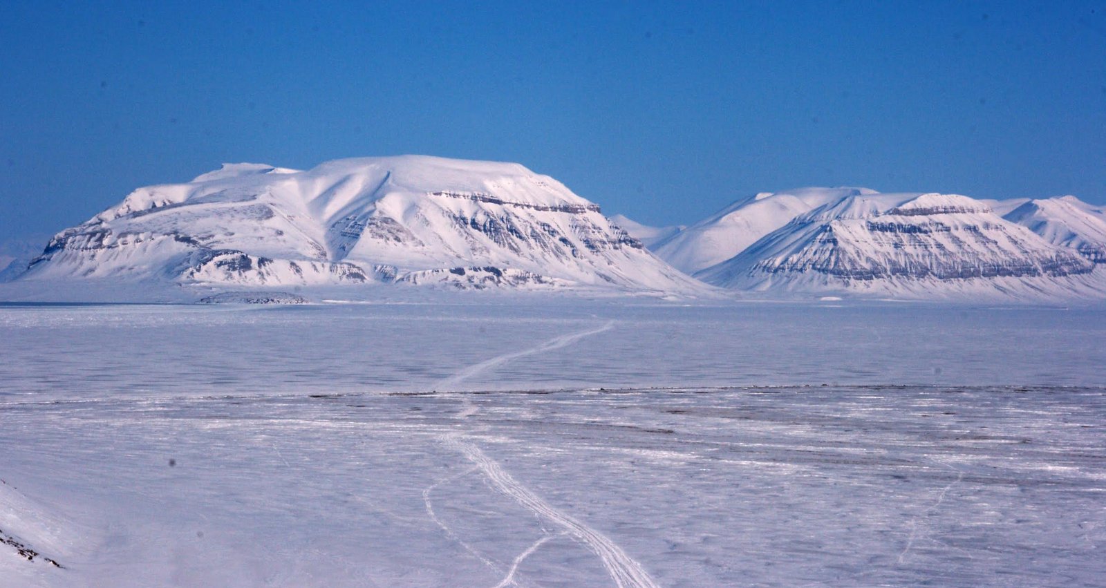 Snowy landscape with mountains as background