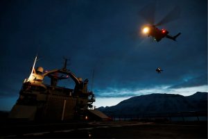 Helicopter approaching vessel at night.