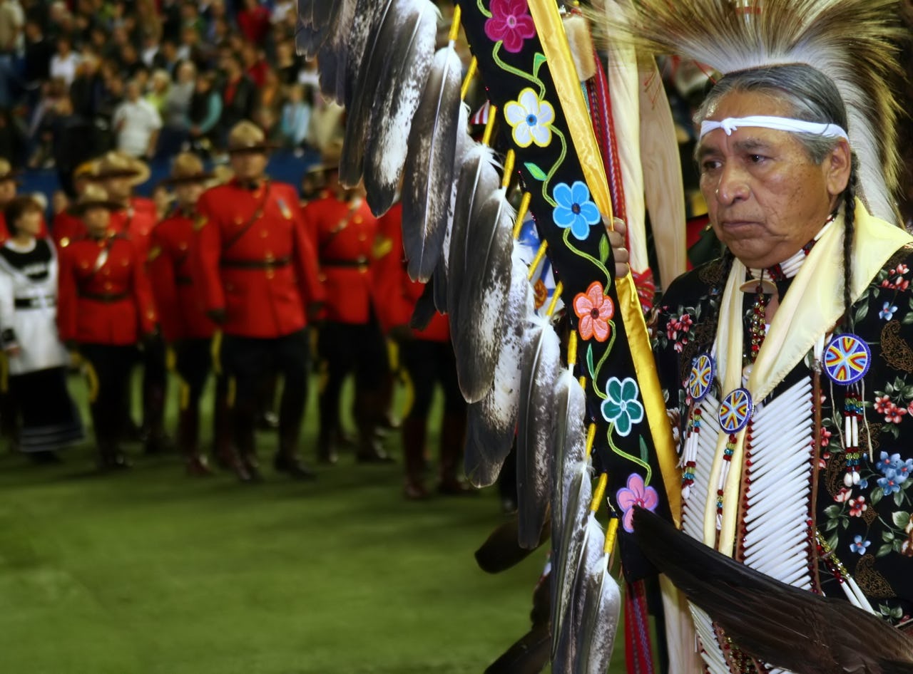 Old man holding indigenous flag