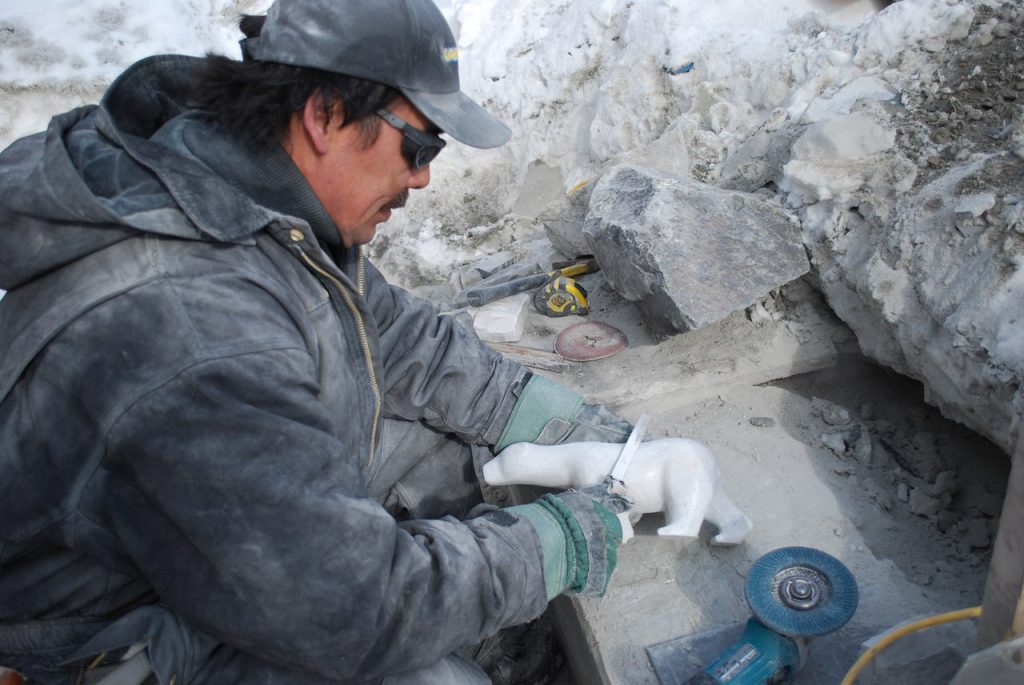 Indigenous Canadian carves polar bear out of soap stone and marble