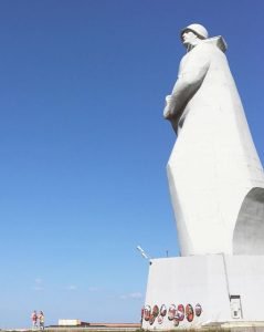 Big soldier statue with blue sky in the background.