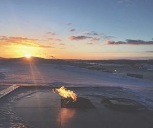 Sun coming over the horizon in icy landscape.