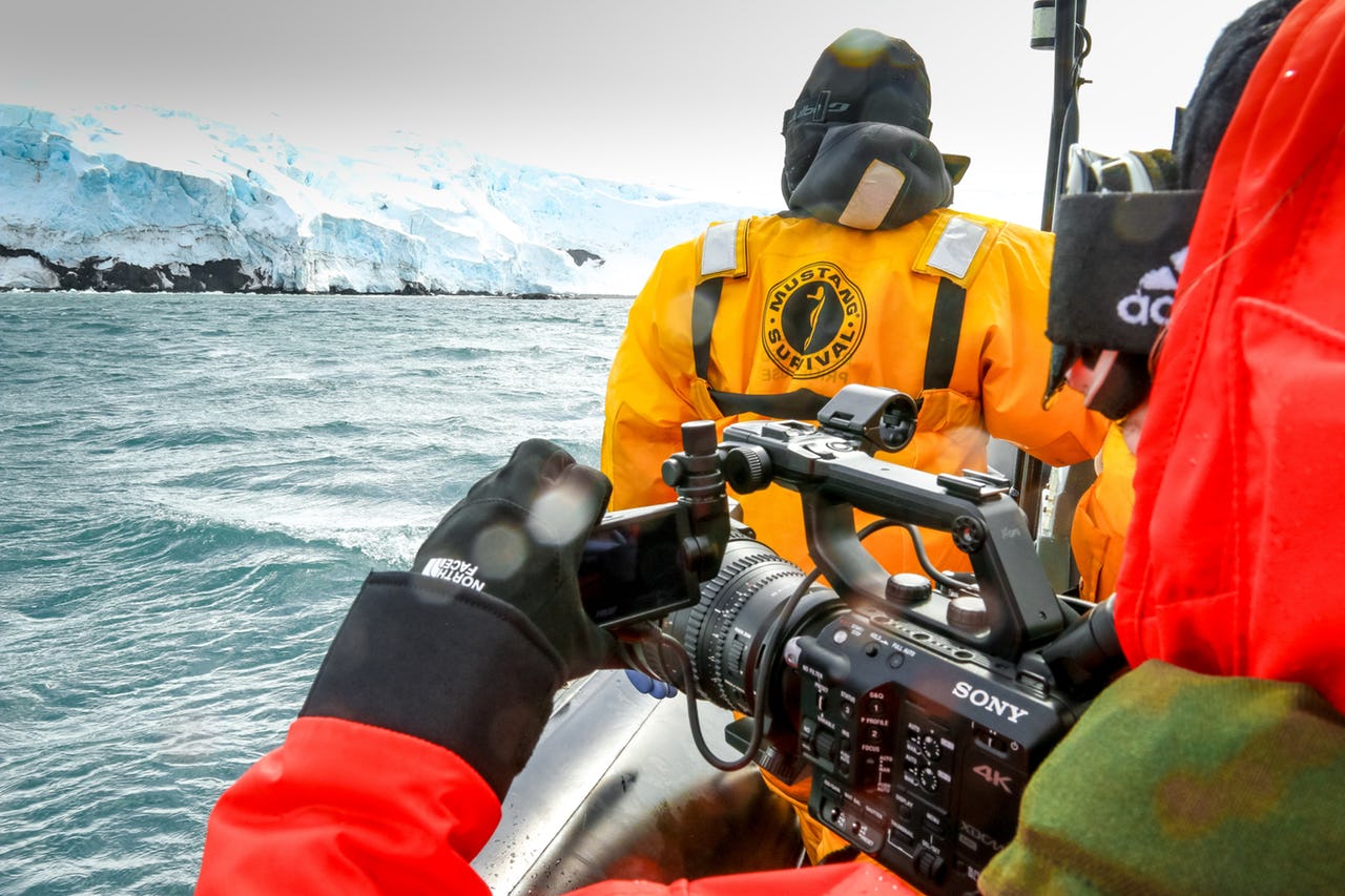 Person filming an iceberg with camera as part of the IMO delegation to Antarctica