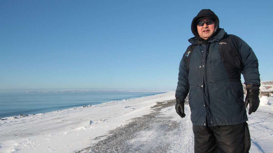 Man in winter standing on the snow-covered waterfront