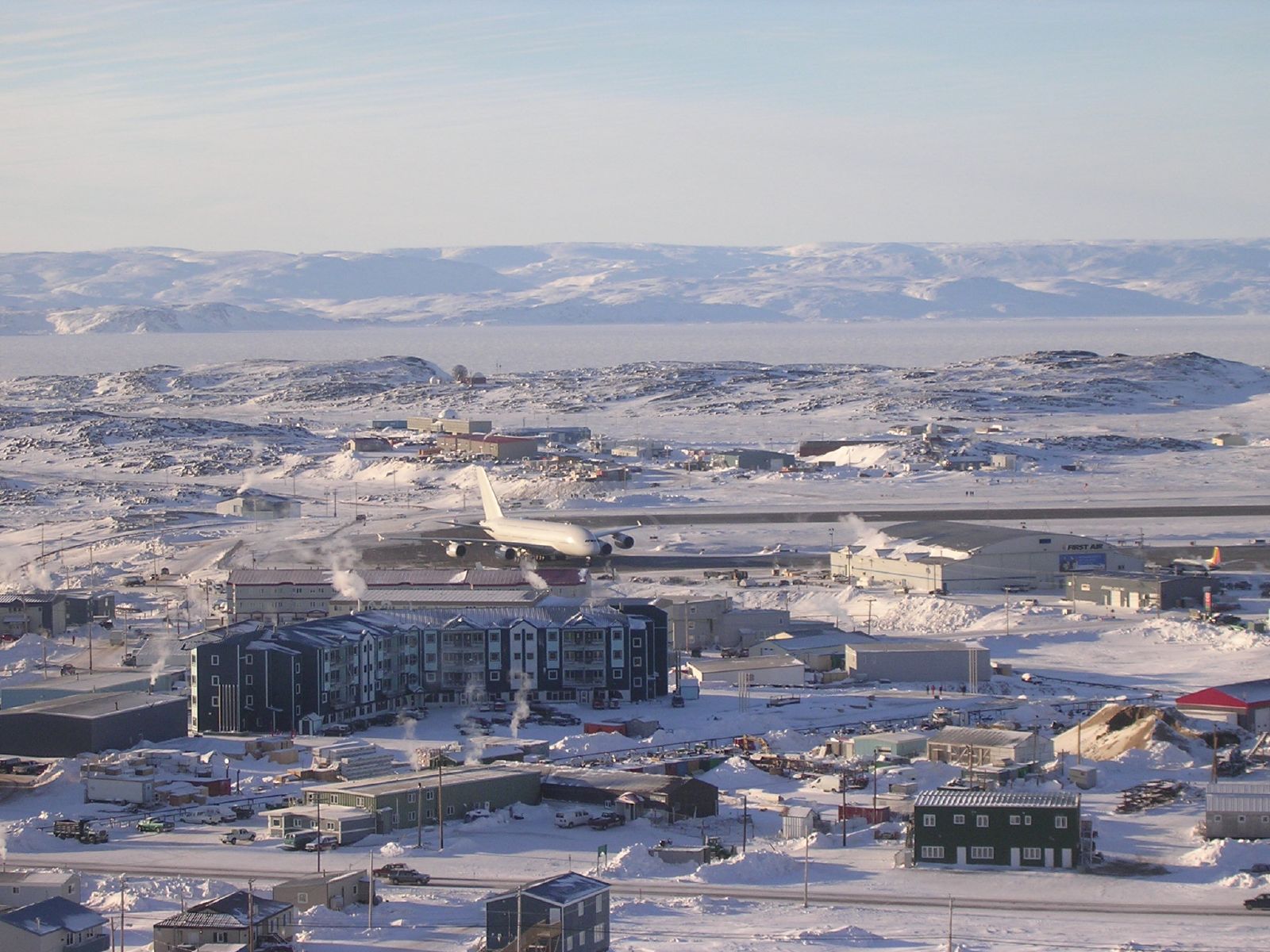 Areal view of town in winter with airplane on runway