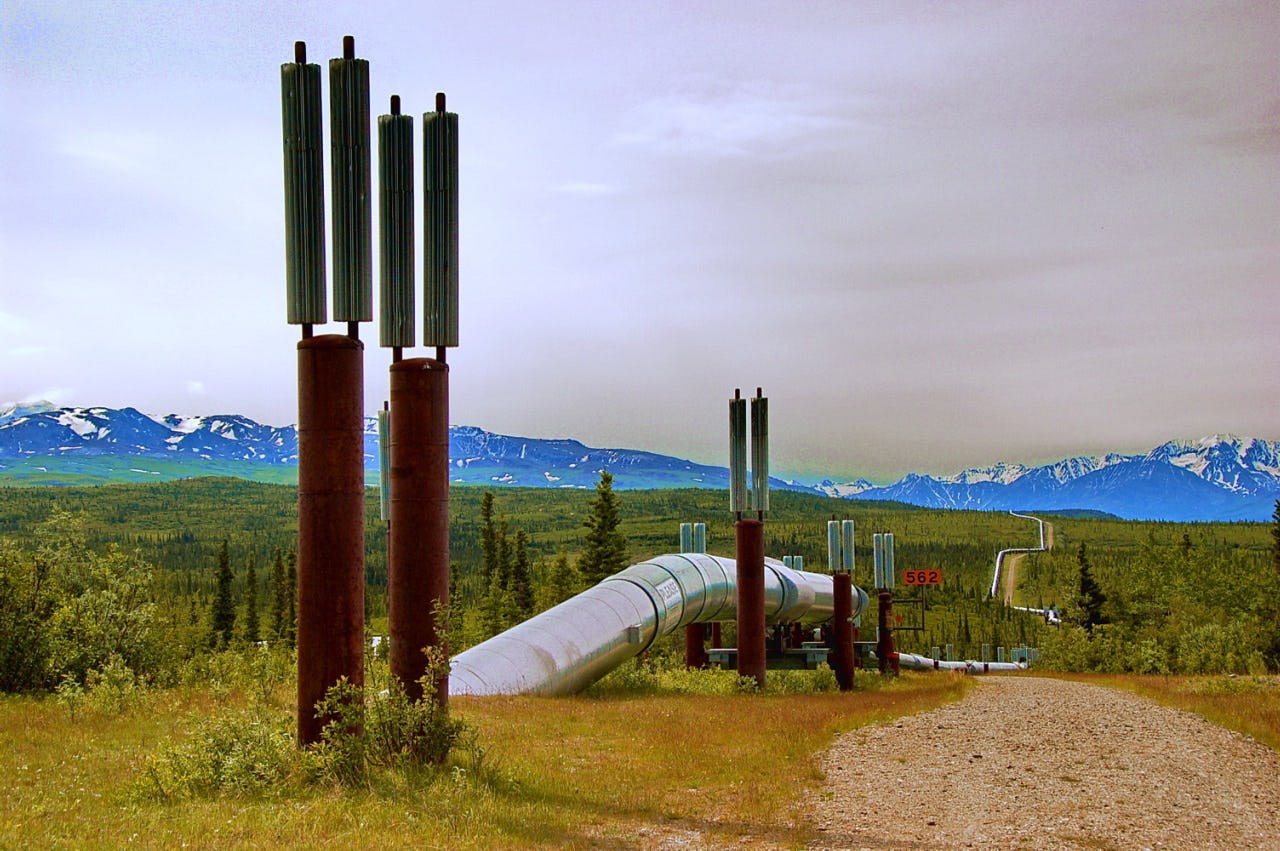 Pipeline running above ground with snowy mountain range in the back