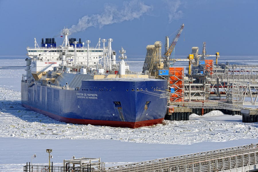 Big blue ship at a dock surrounded by ice-covered waters