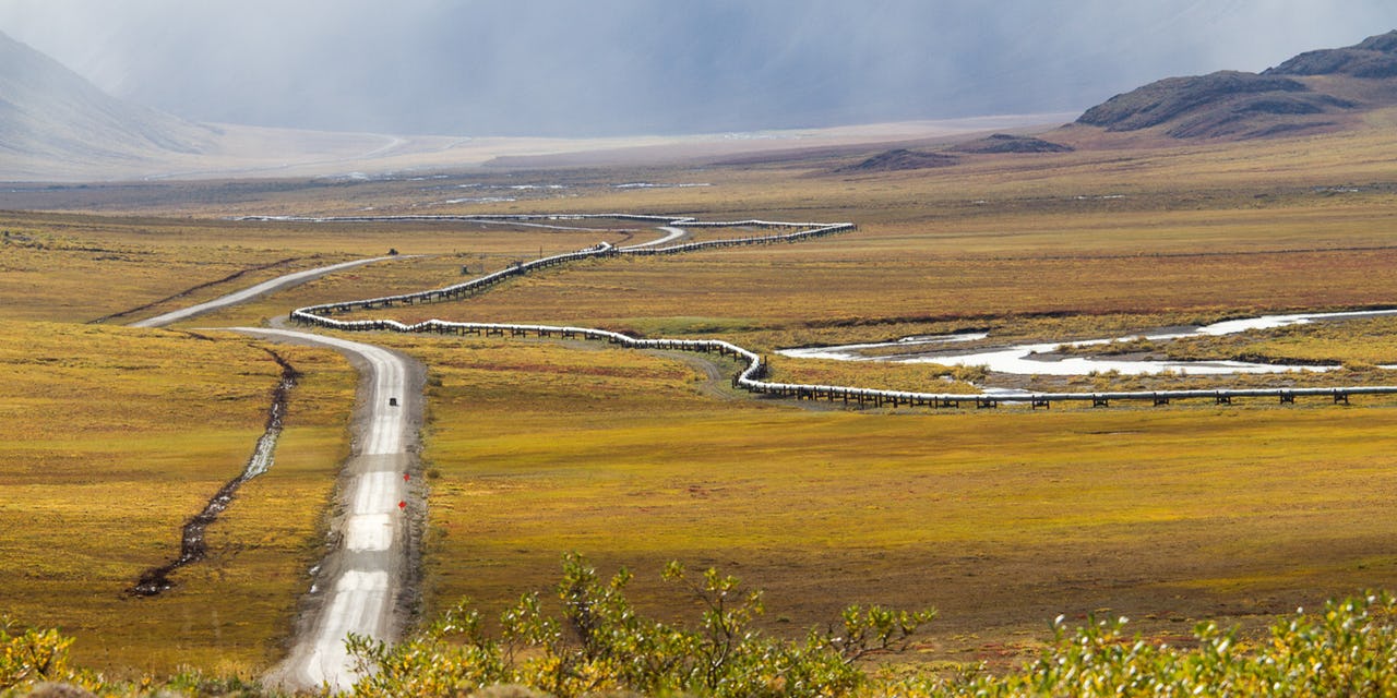 Gravel road next to above-ground pipeline in Alaska