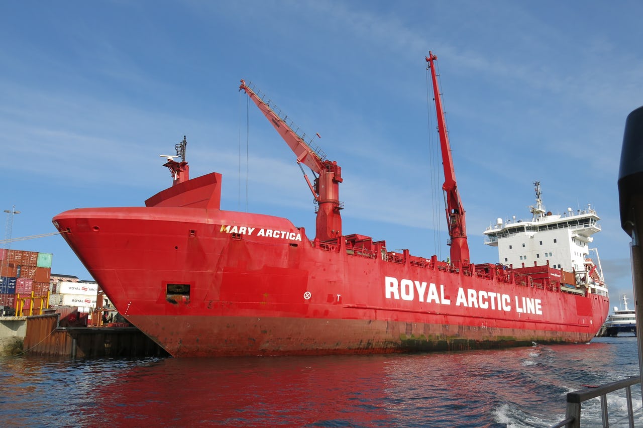 Red ship of Royal Arctic Line against blue sky