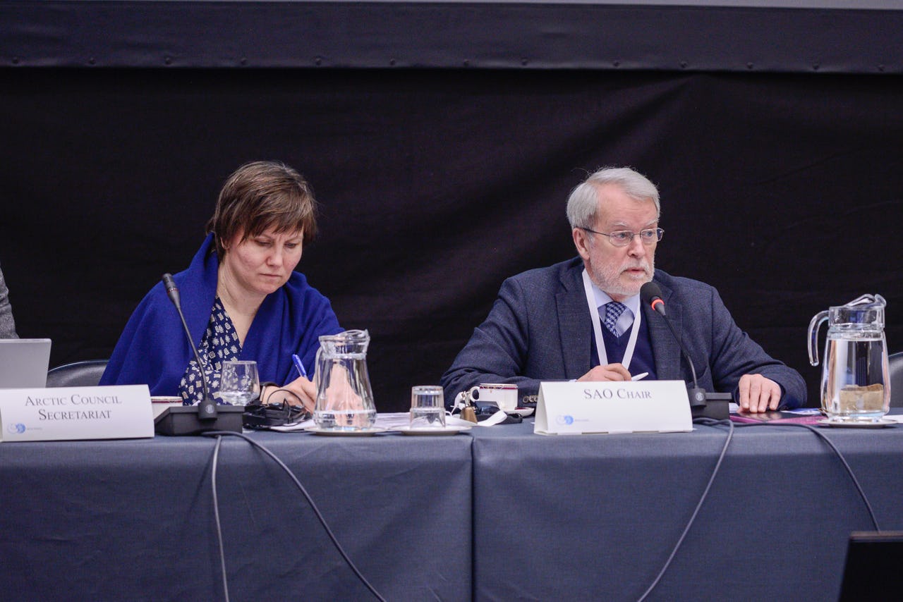 One woman and one man sitting at a table with microphones