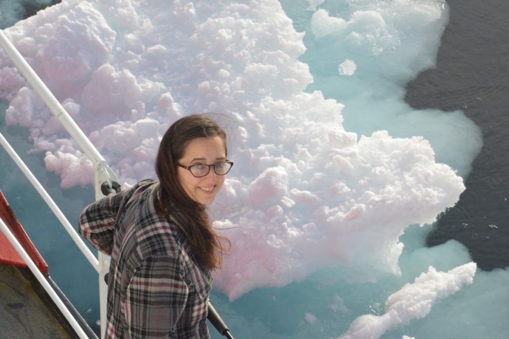 Young woman on a ship with icy waters in the background