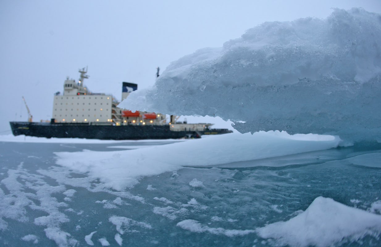 Illuminated icebreaker, the Russian Kapitan Dranitsyn, during an expedition in the Arctic Ocean north of Russia, surrounded by ice.
