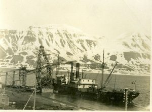 Black and white picture of ships and cranes by the water