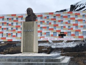 A statue in front of a colourful building