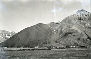 Black and white image of a mountain behind a town