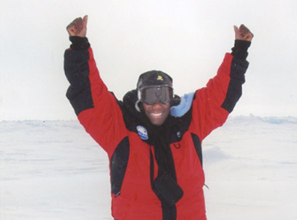 Black woman in red-black snowsuit at North Pole