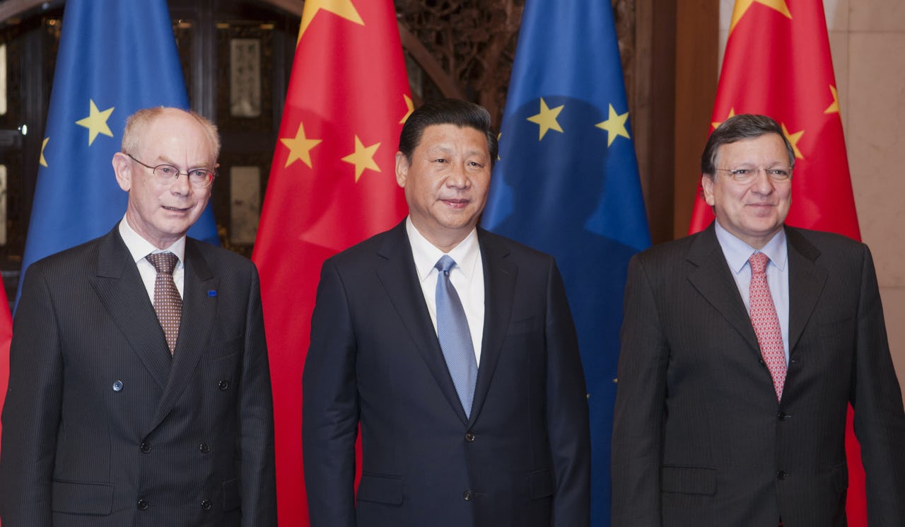 Three men standing in front of four flags of the European Union and China