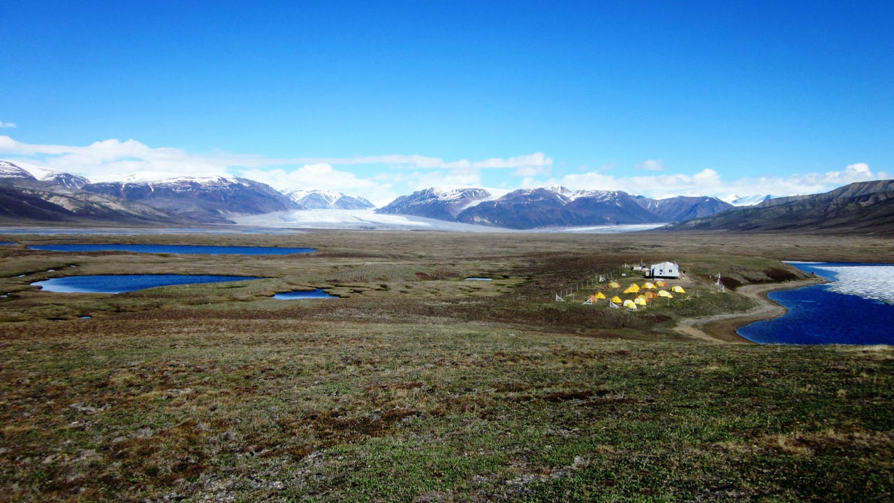 Landscape with mountains in the back and a tent campground to the left