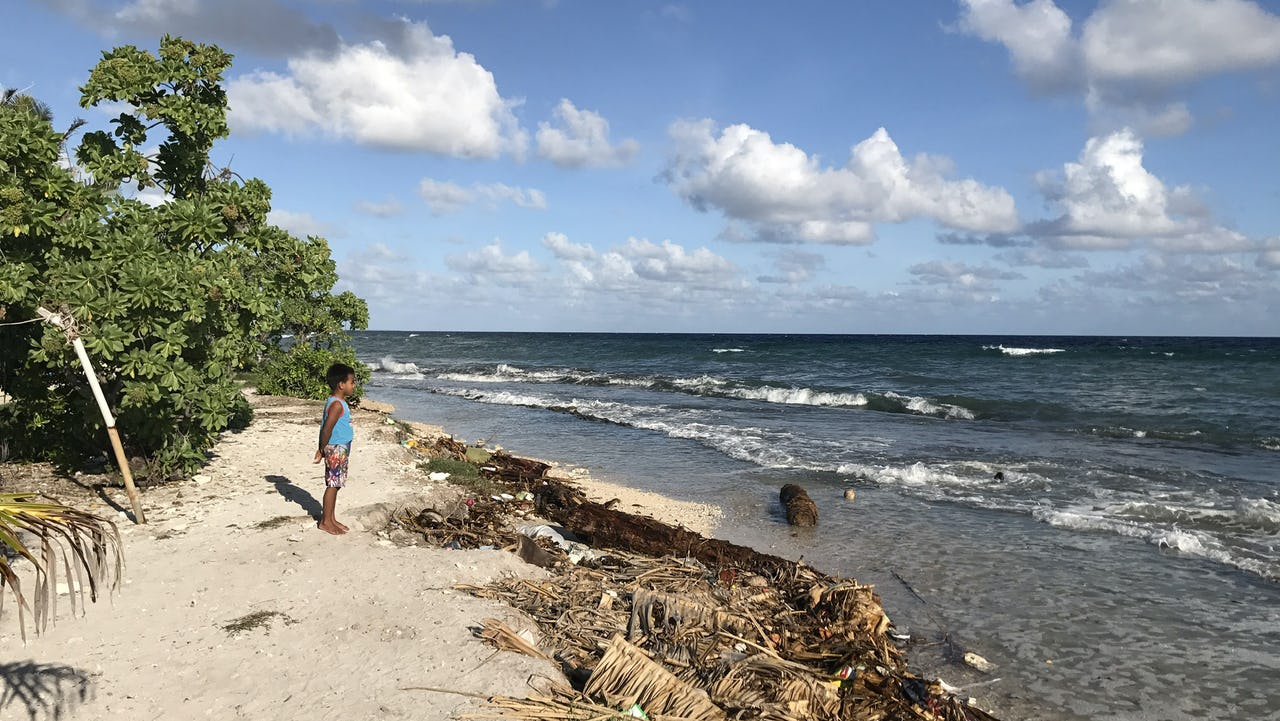 Child standing on the beach looking at the ocean