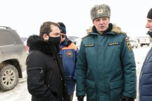 Four men - government officials and emergency workers in winter coats meeting at the site of a coronavirus outbreak in Murmansk Oblast