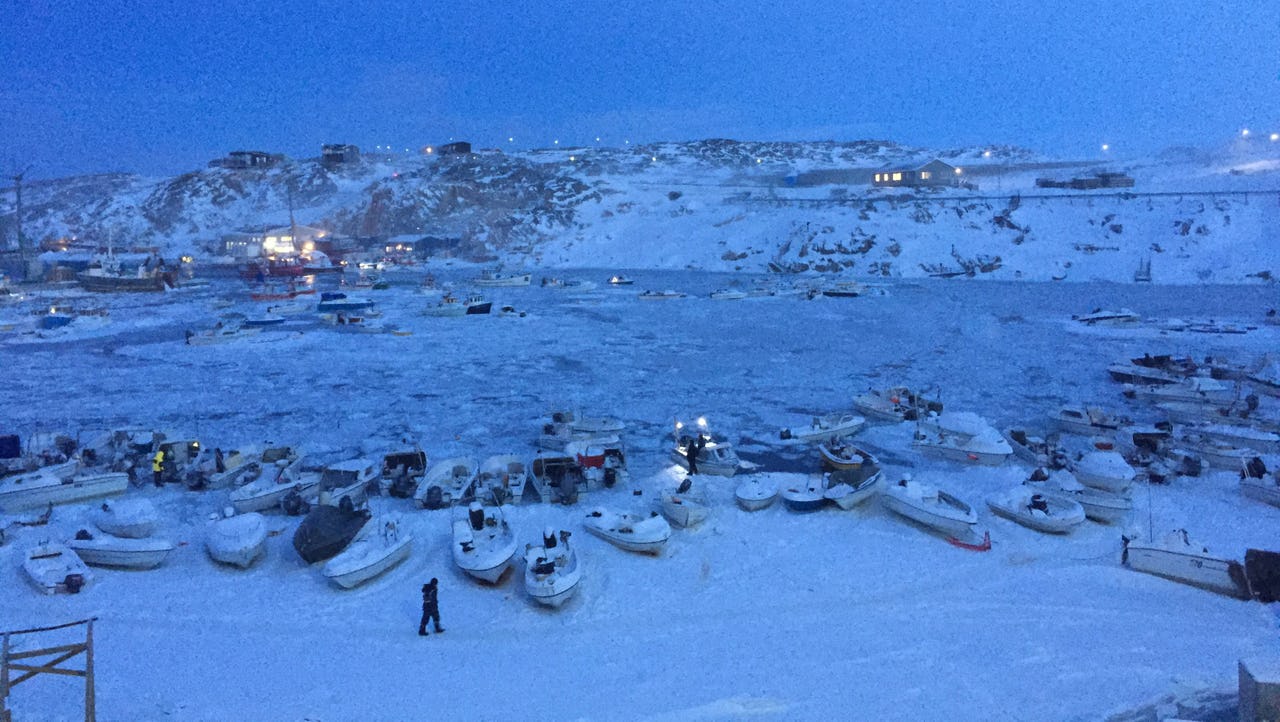 A fisherman walking at the port of Ilulissat in Greenland in January 2020