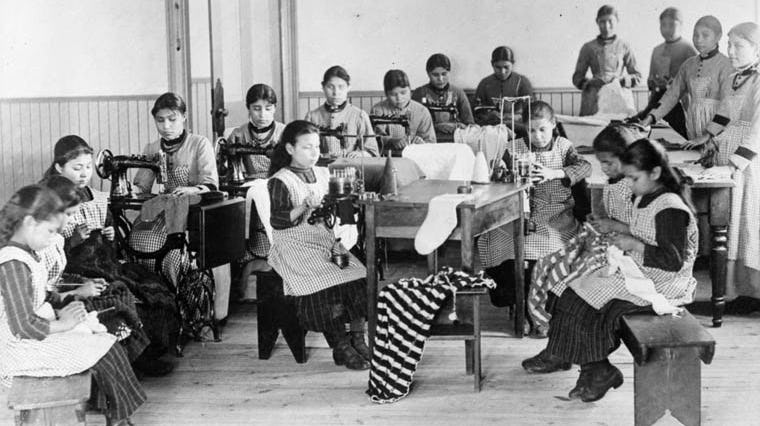 Girls learning how to sew in a classroom in a residential school in Fort Resolution, Northwest Territories