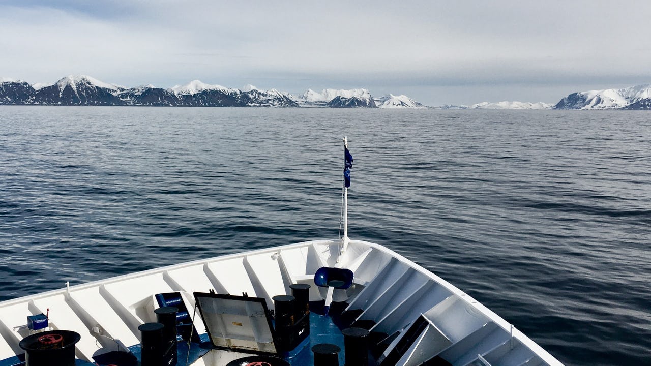 A view from a vessel sailing in calm waters of the Arctic Ocean near Svalbard in summer time