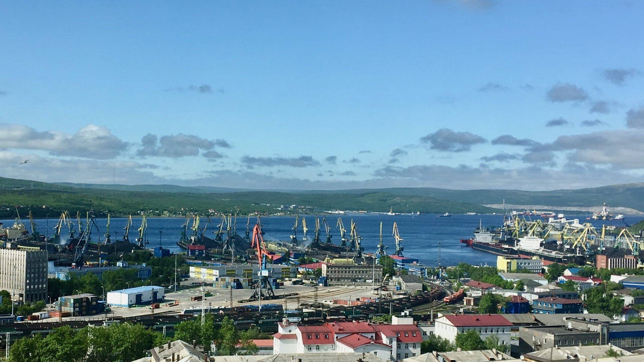 A sunny day in a port of Murmansk in Russia. A city view toward the Kola Bay where a myriad of ships are at anchor