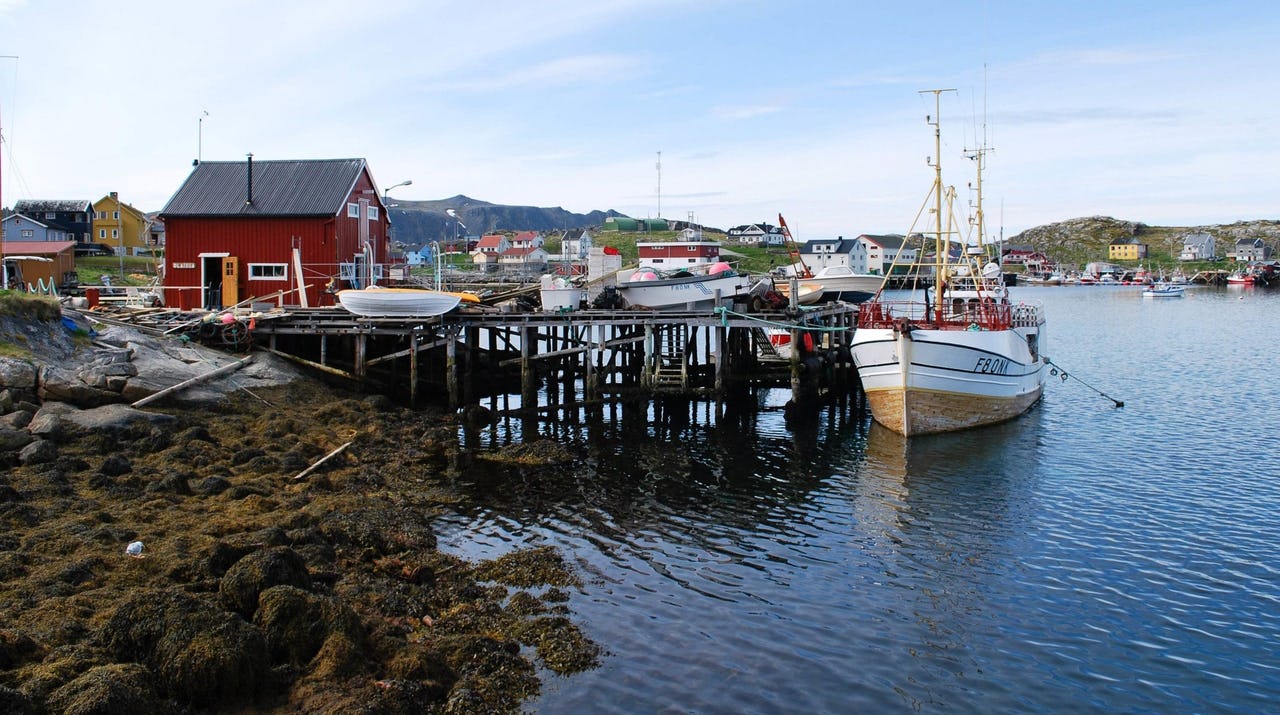 A fishing boat docks at a small Norwegian fishing village