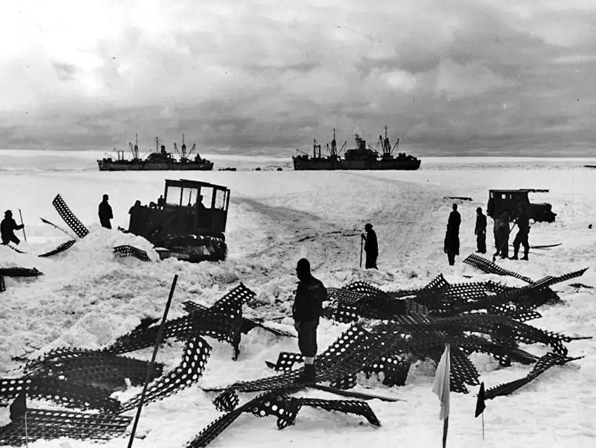 Black and white image showing bulldozers clearing path through Antarctic snow