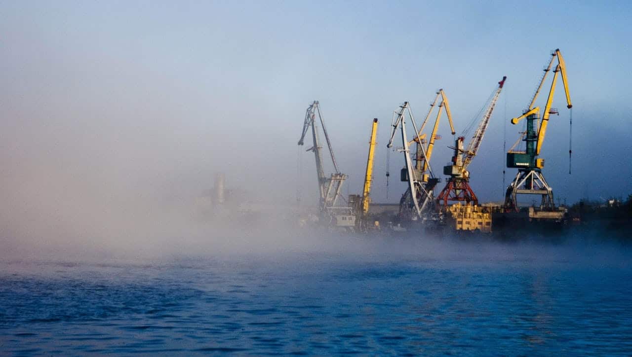 Four dockside cranes slightly shrouded in fog