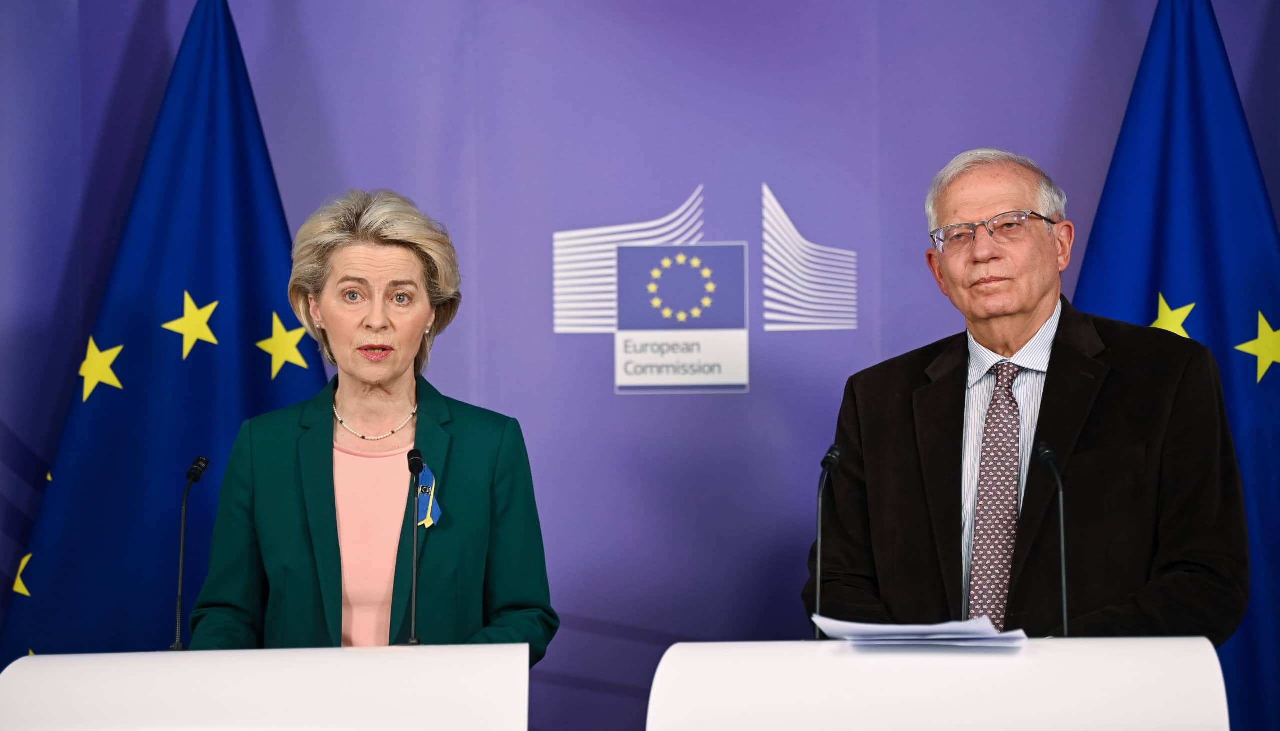 Ursula von der Leyen and Josep Borrell Fontelles standing in front of EU flags and the European Commission's logo holding a statement