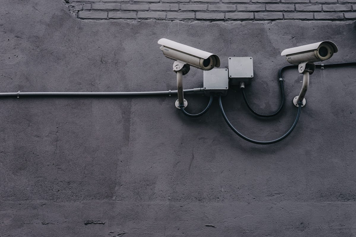 Two public surveillance cameras mounted on a wall