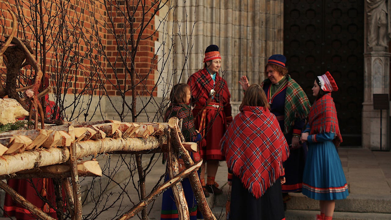 A group of delegates representing Indigenous peoples of the European Arctic standing in front of the cathedral in Uppsala, Sweden