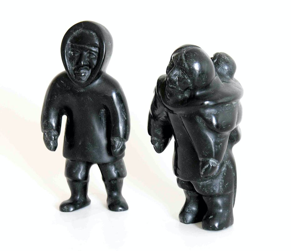 An Inuit sculpture of a man and a woman carrying a child