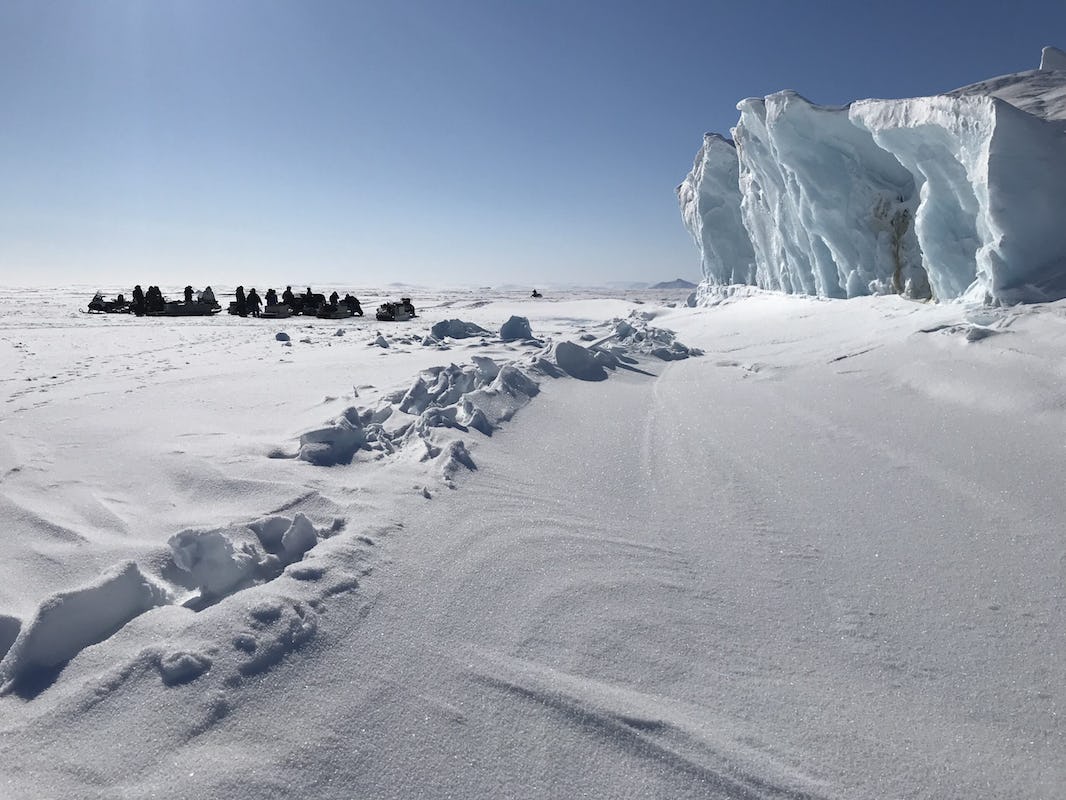 A group of researchers engaged gathers on the sea ice near Clyde River, Nunavut on a spring day