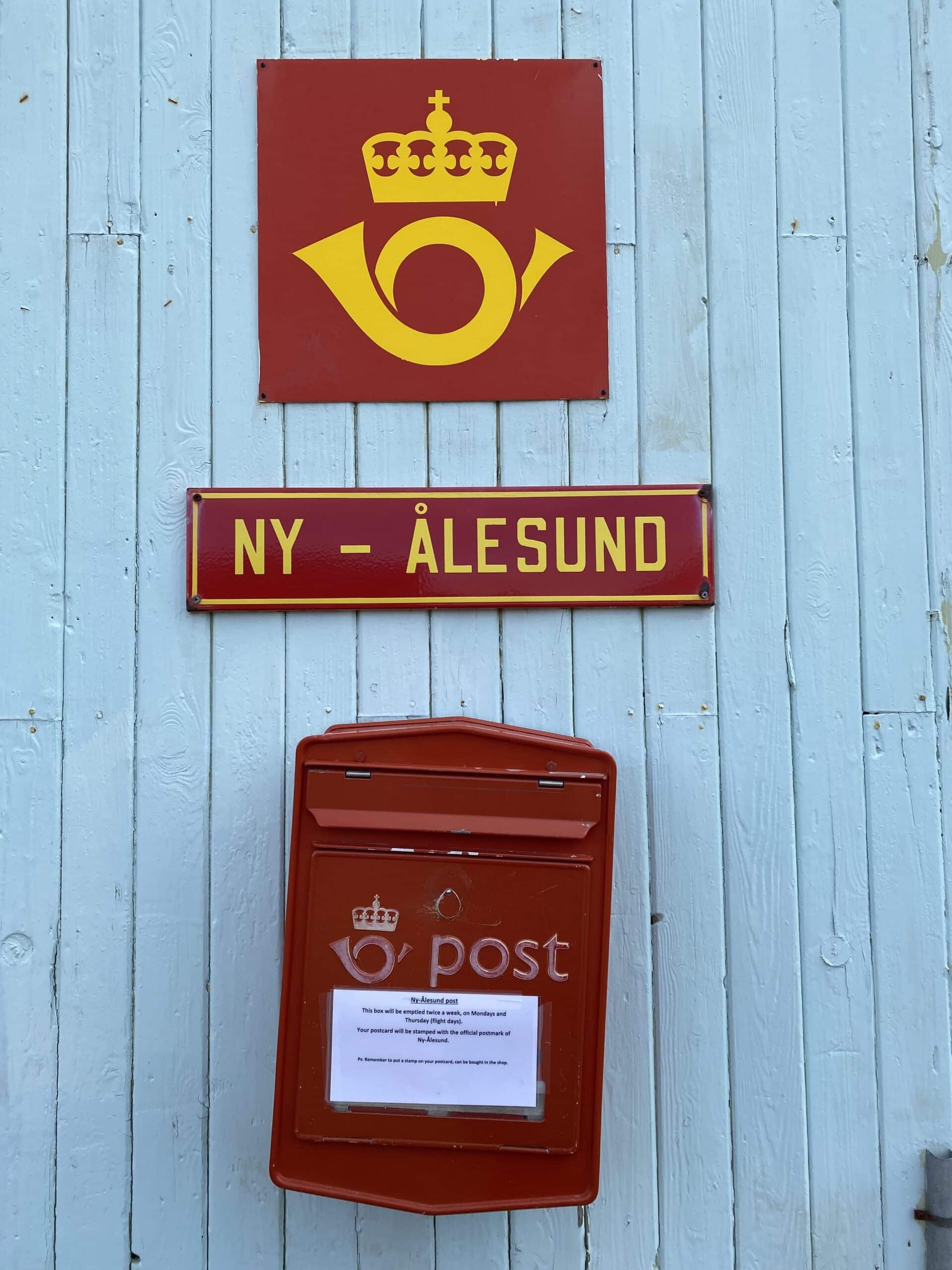 Red post box with post office sign on a wodden house in Ny-Ålesund