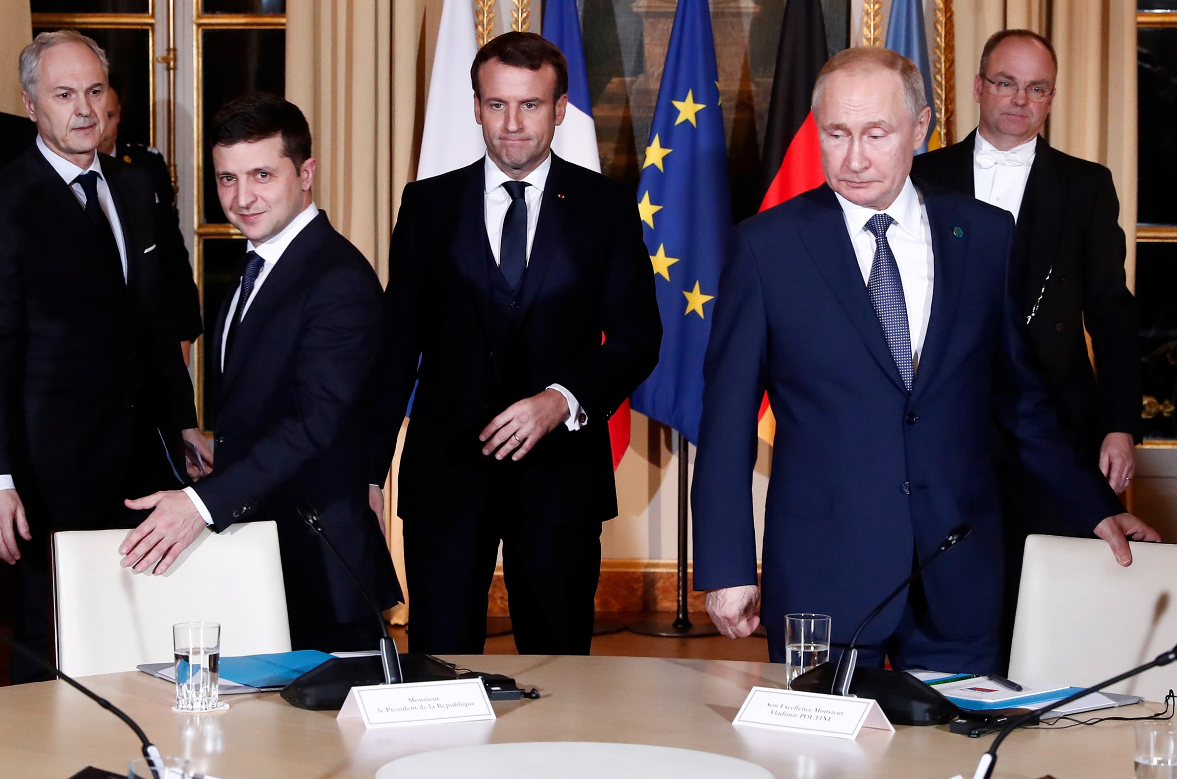 Five men, including Volodymyr Zelensky, Emmanuel Macron and Vladimir Putin, in front of a round table