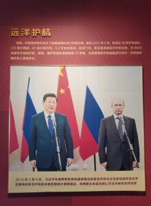 A poster of Chinese President Xi Jinping and Russian President Vladimir Putin with Chinese text against a red wall