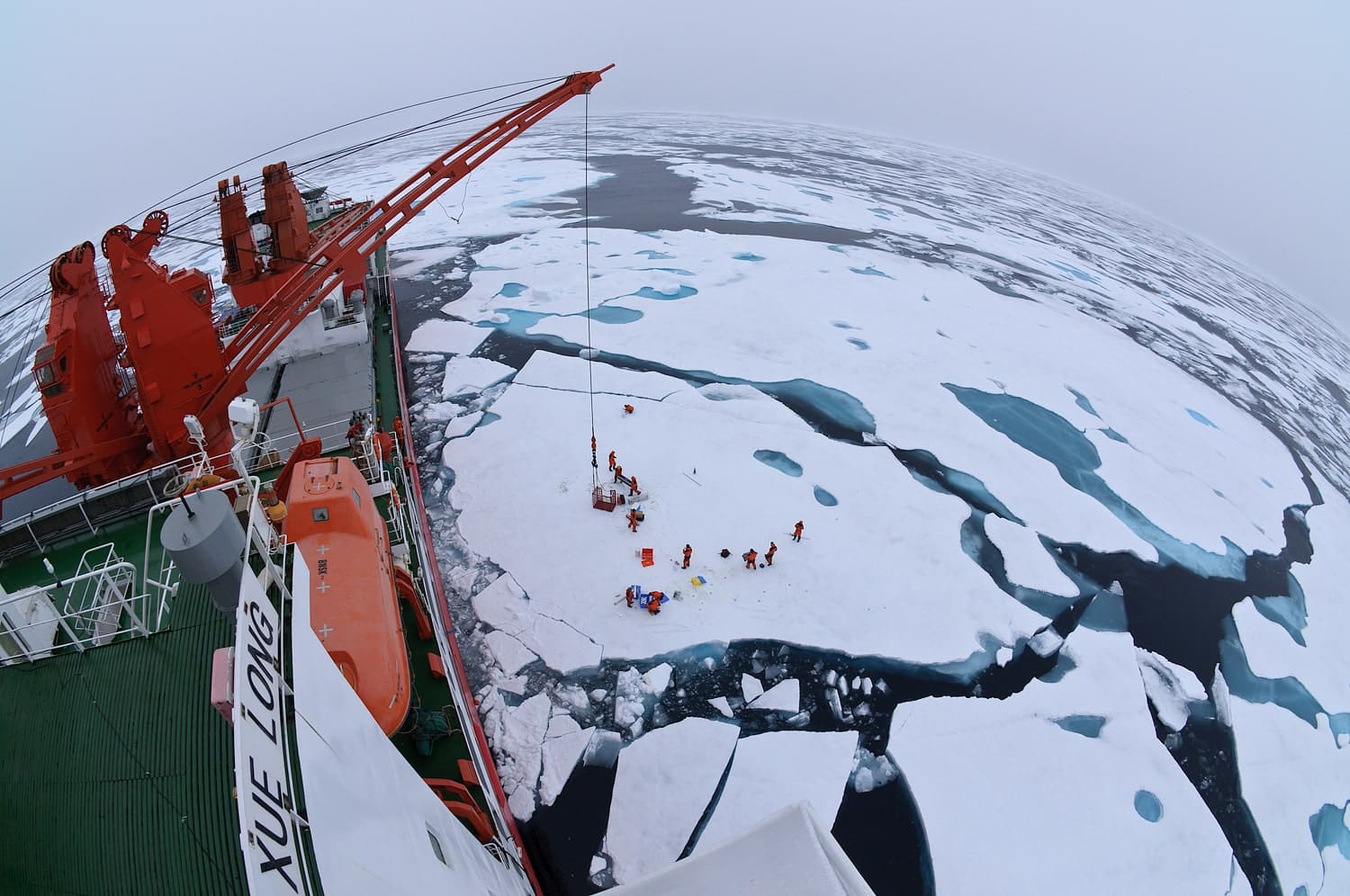 Chinese researchers conducting field work on sea ice in the Arctic Ocean next to the Xue Long research vessel