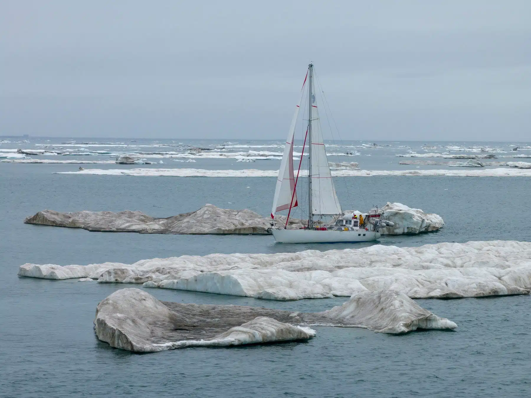 A sailboat sailing in between ice