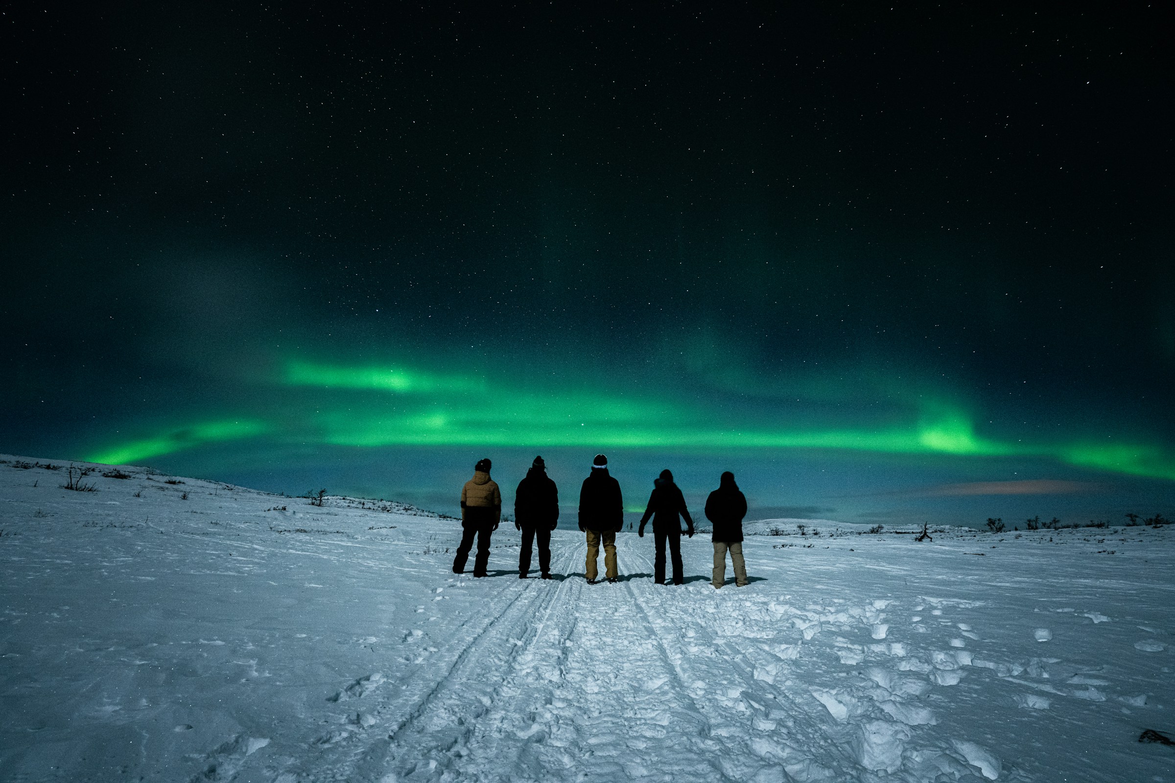 A group of people standing on top of a snow covered slope