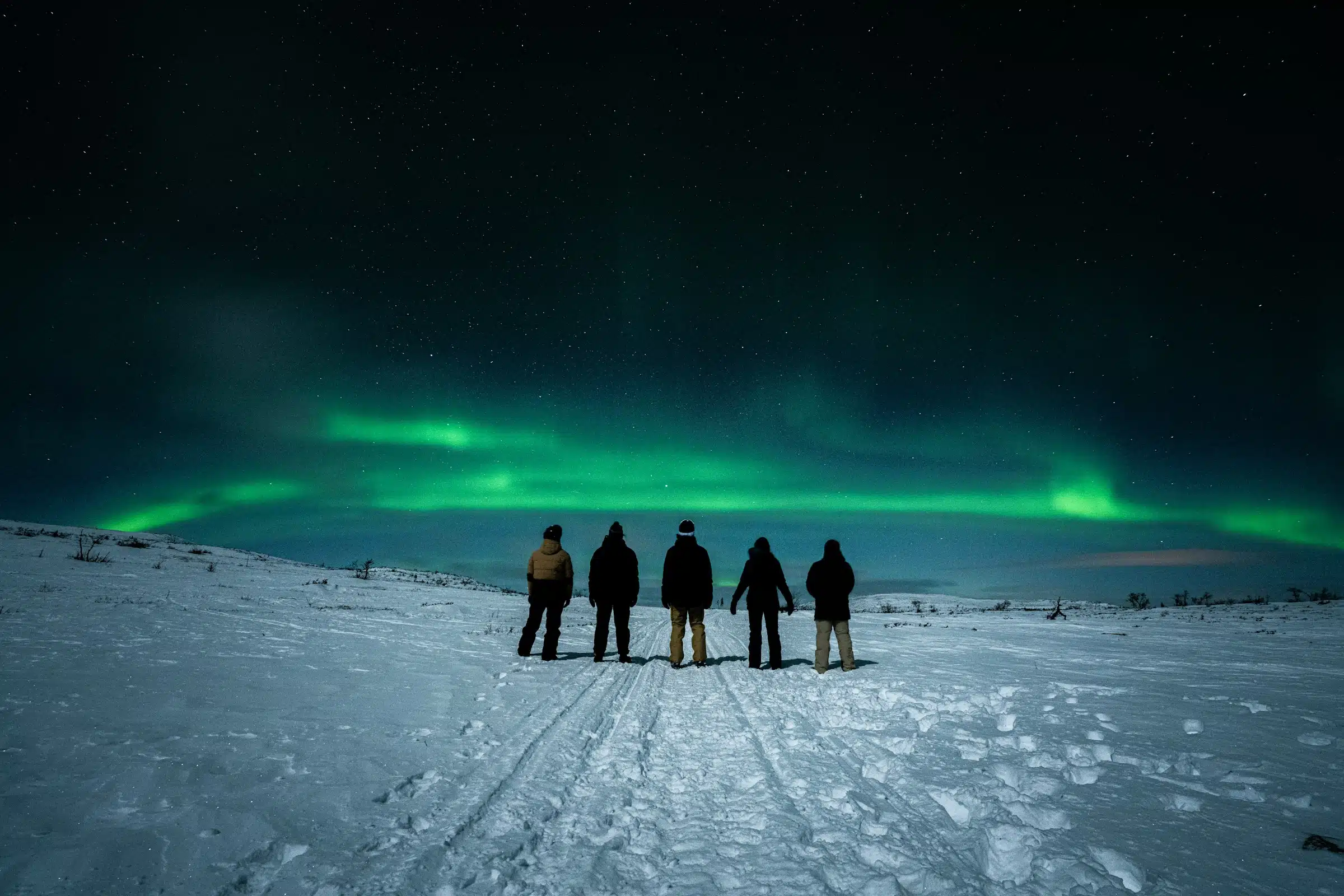A group of people standing on top of a snow covered slope
