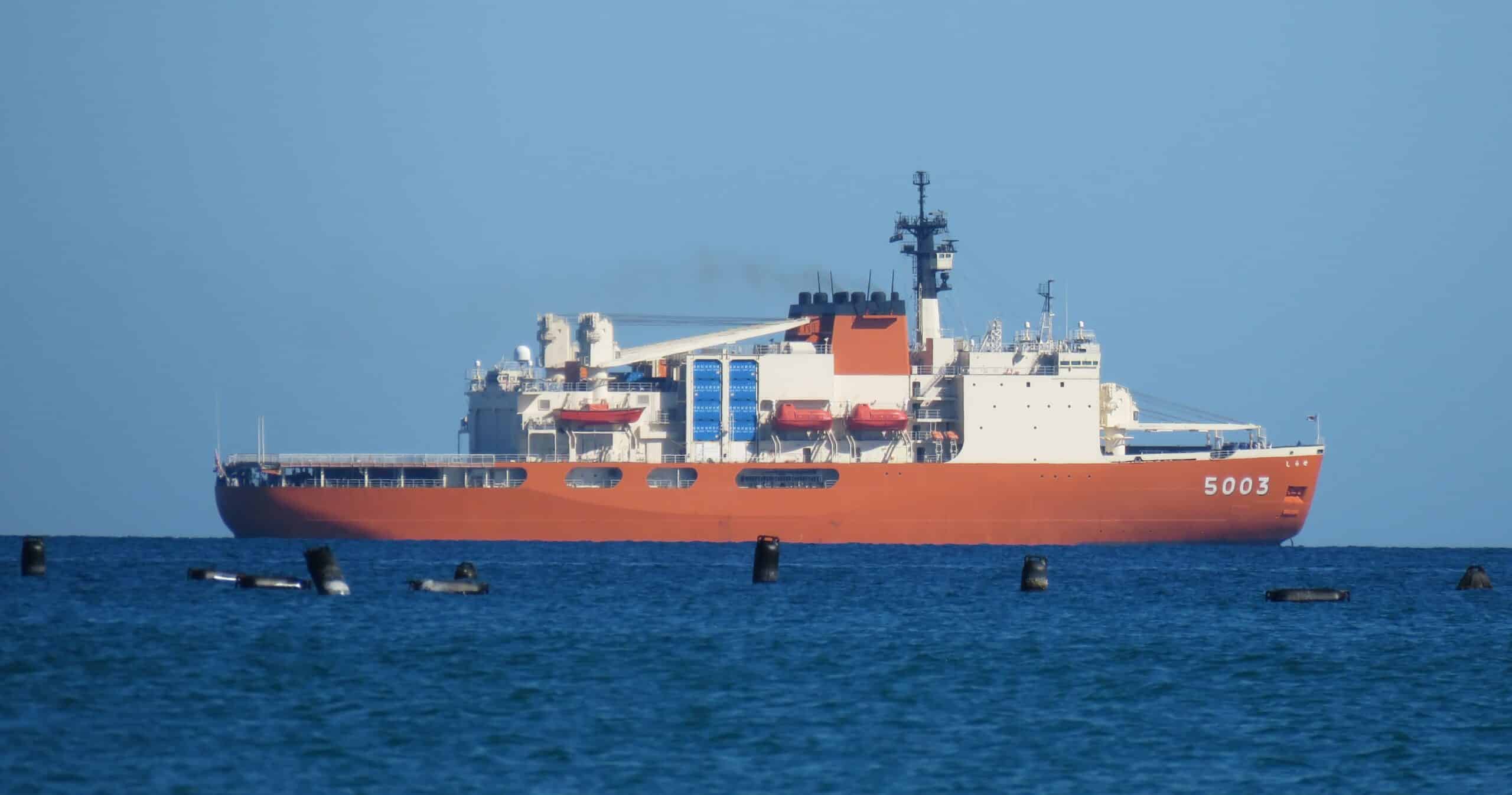 A large red ship on blue water