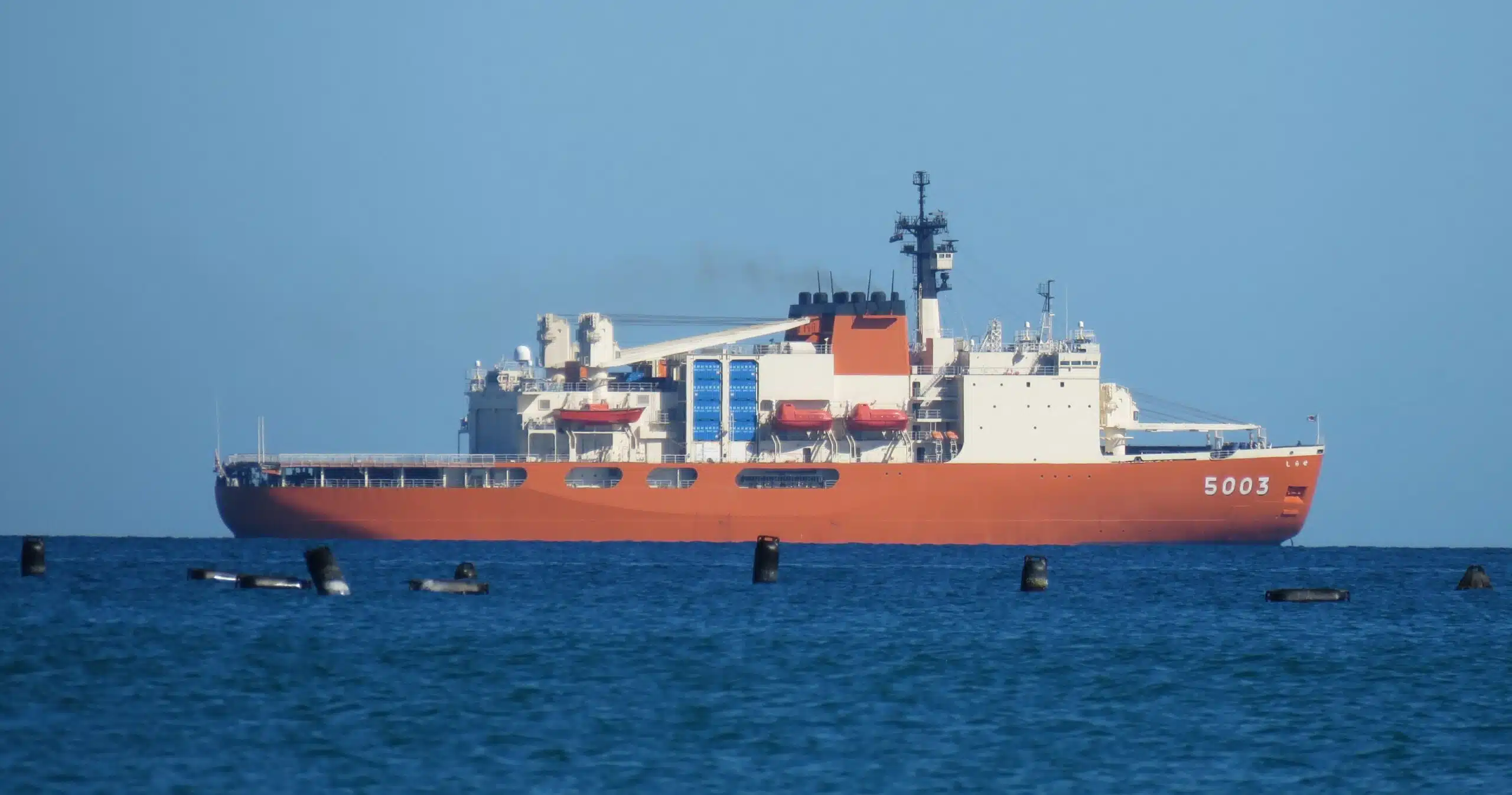 A large red ship on blue water