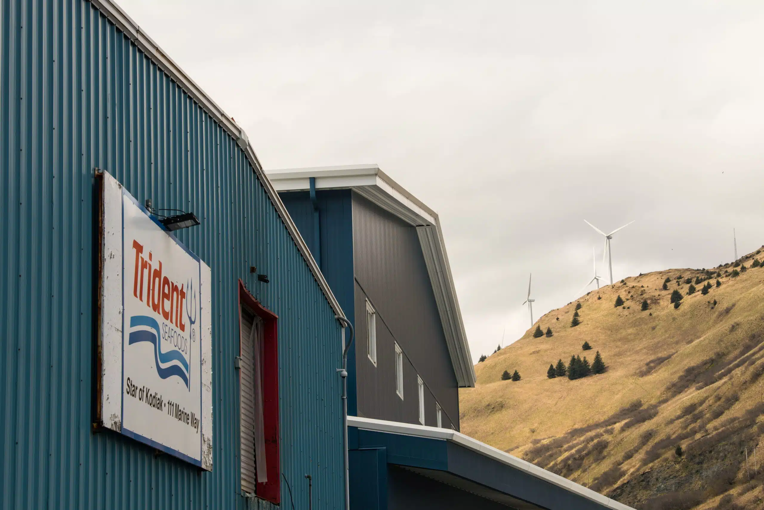 Kodiak, Alaska fish packing plant with wind turbines showcasing clean energy infrastructure